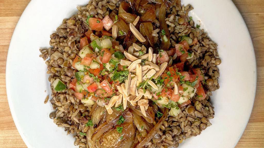 Mujaddarah (Lunch) · A cardamom-spiced brown rice and whole brown lentils pilaf, topped with caramelized onions, toasted almonds and shepherd's salad.