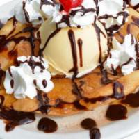 Sopapilla With Ice Cream · A Sopapilla topped with ice cream, whipped cream, chocolate syrup, and a cherry.