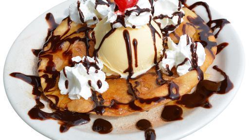 Sopapilla With Ice Cream · A Sopapilla topped with ice cream, whipped cream, chocolate syrup, and a cherry.