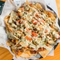 Creole Nachos · Patton’s hot sausage, creole red beans, queso, shredded cheddar, jalapeño, diced tomato, gre...