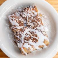 White Chocolate Bread Pudding · Topped with white chocolate sauce and powdered sugar