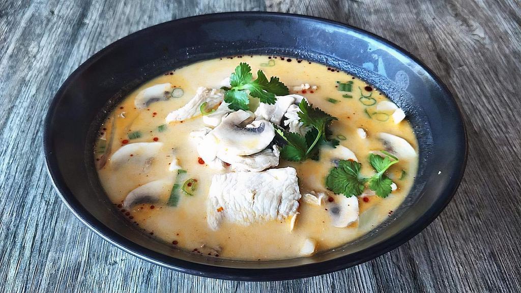 Tom Kha (Bowl) · Coconut milk with lime juice, galangal, and Thai herbs.