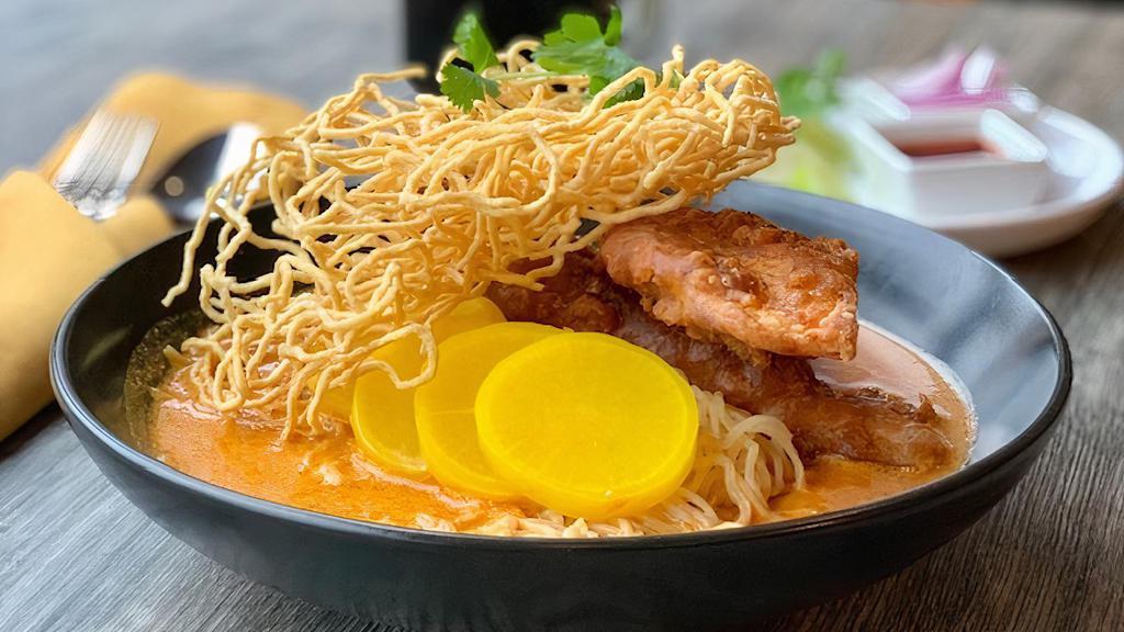 Khao Soi · (Spicy) Fried tilapia or fried chicken with egg noodles, red onions, pickled daikon top with crispy noodles.