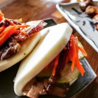 Pork Belly Buns (2) · Thick slices of chashu with lightly pickled carrots and cucumber in a soft bao bun. Drizzled...