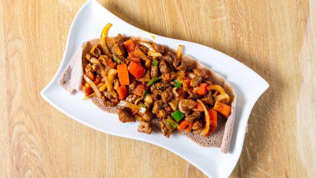 Awaze Tibs · Lean beef sautéed with fresh rosemary onions, jalapeño peppers, fresh tomatoes and garlic, sautéed in our special awaze sauce with your choice of Beef,Chicken or lamb. (mild to spicy).