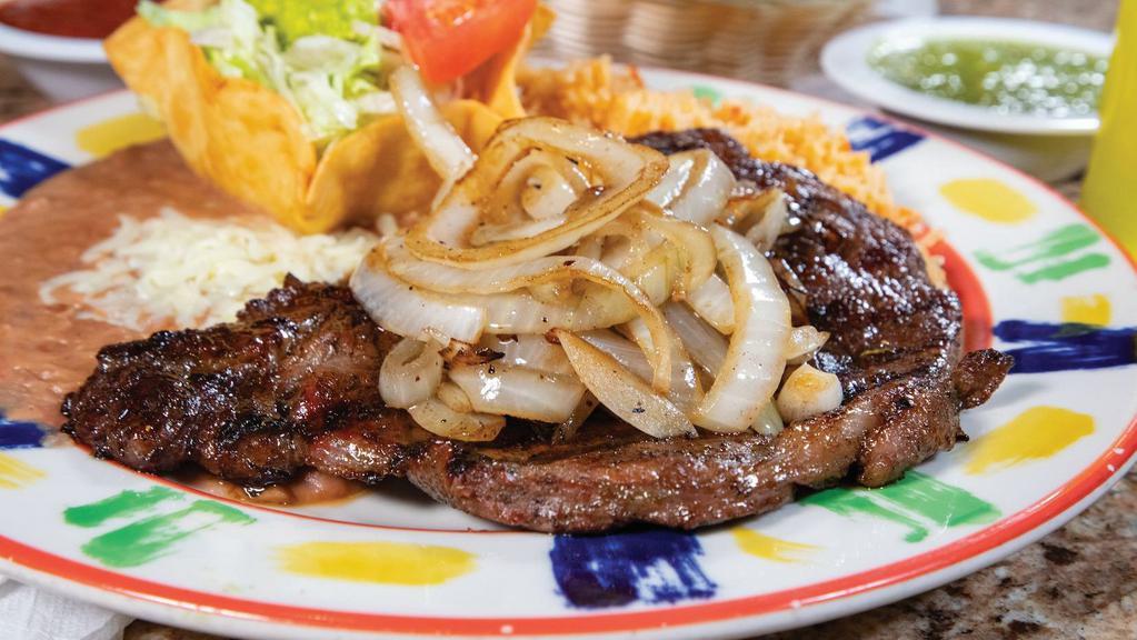 Mp- Beef Steak A La Tampiquena · 8oz. ribeye steak topped with grilled onions. Served with Mexican rice, refried beans, and guacamole salad. Choice of flour or corn tortillas.
