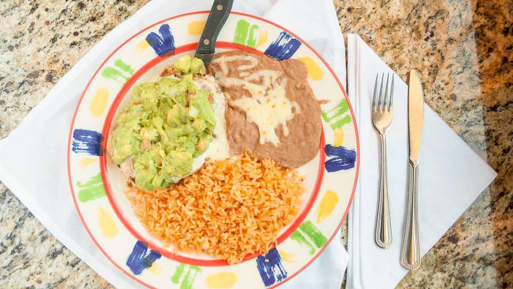 Guaca Chicken · 8oz. Grilled seasoned chicken breast topped with our delicious queso sauce and homemade guacamole. Served with rice & beans.