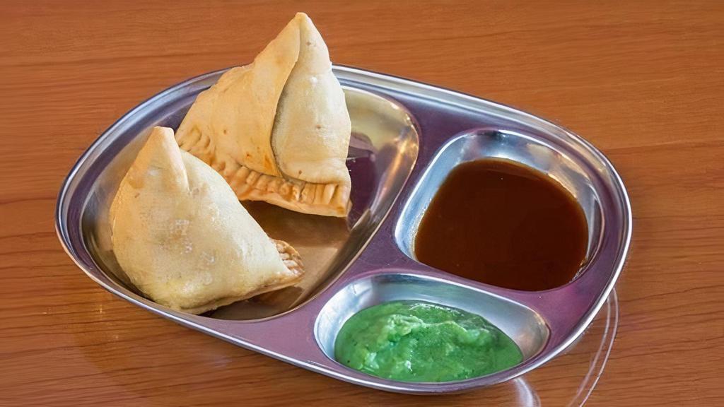 Vegetable Samosa · Deep fried crisp pastries stuffed with mildly spiced potatoes and peas. Served with savory sauces.