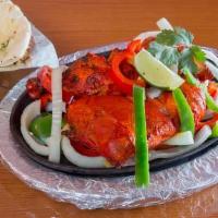 Chicken Tandoori · Chicken marinated in yogurt, mild spices, and herbs. Baked in a special clay oven and served...