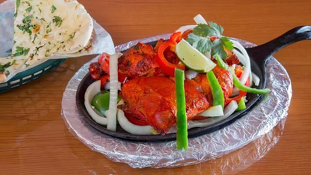 Chicken Tandoori · Chicken marinated in yogurt, mild spices, and herbs. Baked in a special clay oven and served with channa masala.
