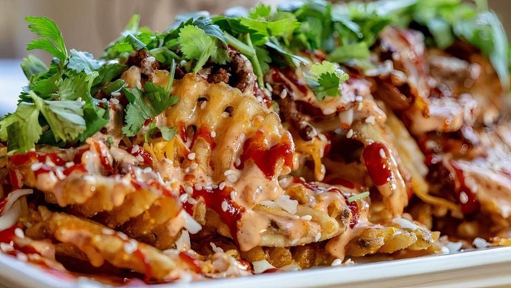 Kim Chi Fries (Vegan) · Waffle fries, vegan kim chi, topped w/ cilantro, vegan signature sauces.