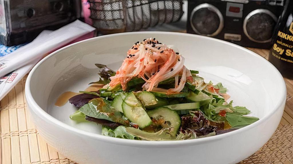 Cucumber Salad · Thinly sliced cucumbers in a Japanese style marinade topped with toasted sesame seeds. Tangy and Fresh!