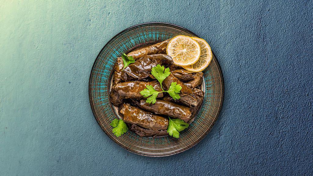 Stuffed Grape Leaves · Grape leaves are filled with a mixture of rice, onions, mint and spices, and then gently steamed. Served with a side of tzatziki sauce.