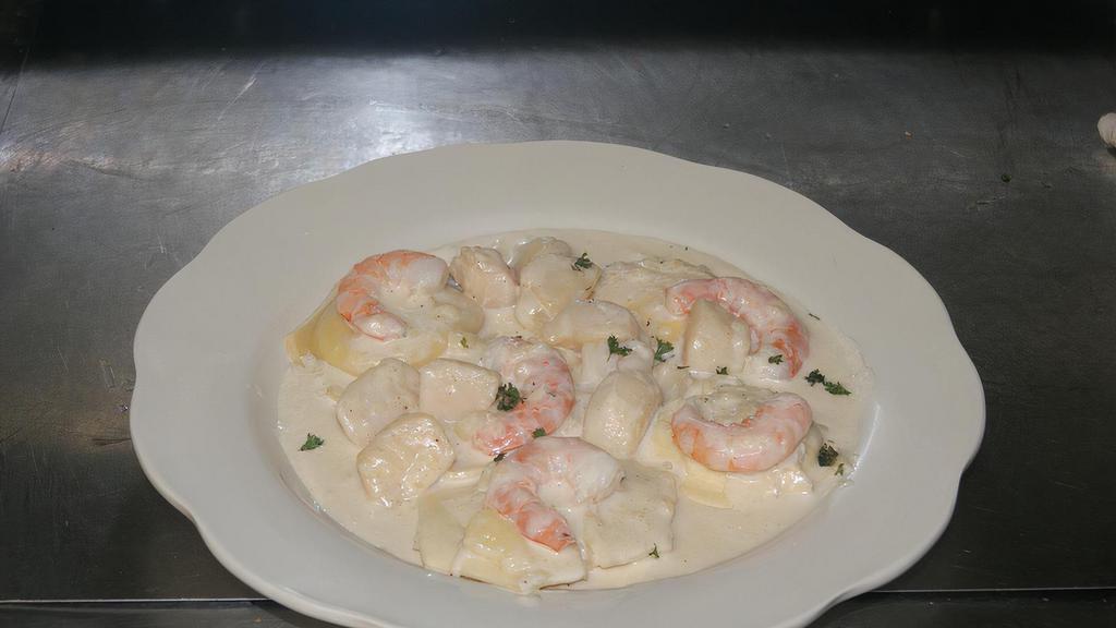 Lobster Ravioli Di Mari · with shrimp and scallops in a creamy wine sauce