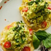 Vegan Guacamole Tostadas · Thick, homemade, deep-fried tortillas topped with mixed greens & a generous portion of guaca...