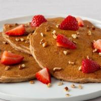 Multi Grain Fruit & Nut  Pancakes · 3 fluffy pancakes filled with banana slices and topped with fresh strawberries and pecans