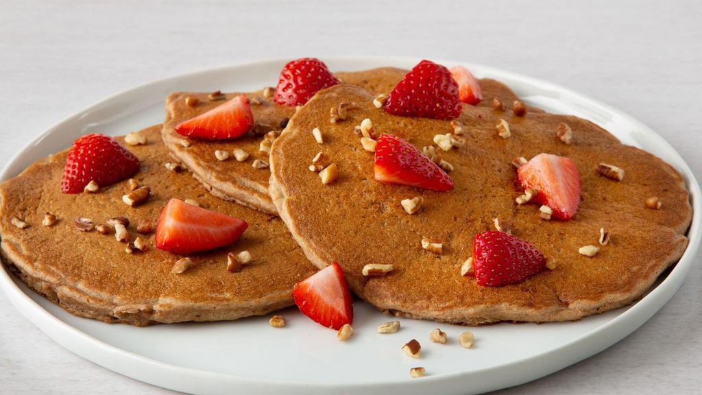 Multi Grain Fruit & Nut  Pancakes · 3 fluffy pancakes filled with banana slices and topped with fresh strawberries and pecans