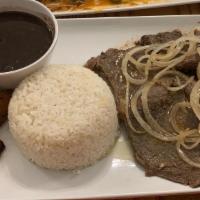 Bistec A La Palomilla Platter · Juicy sirloin steak with mojo citrus topped with sautéed onion. Served with white rice, blac...