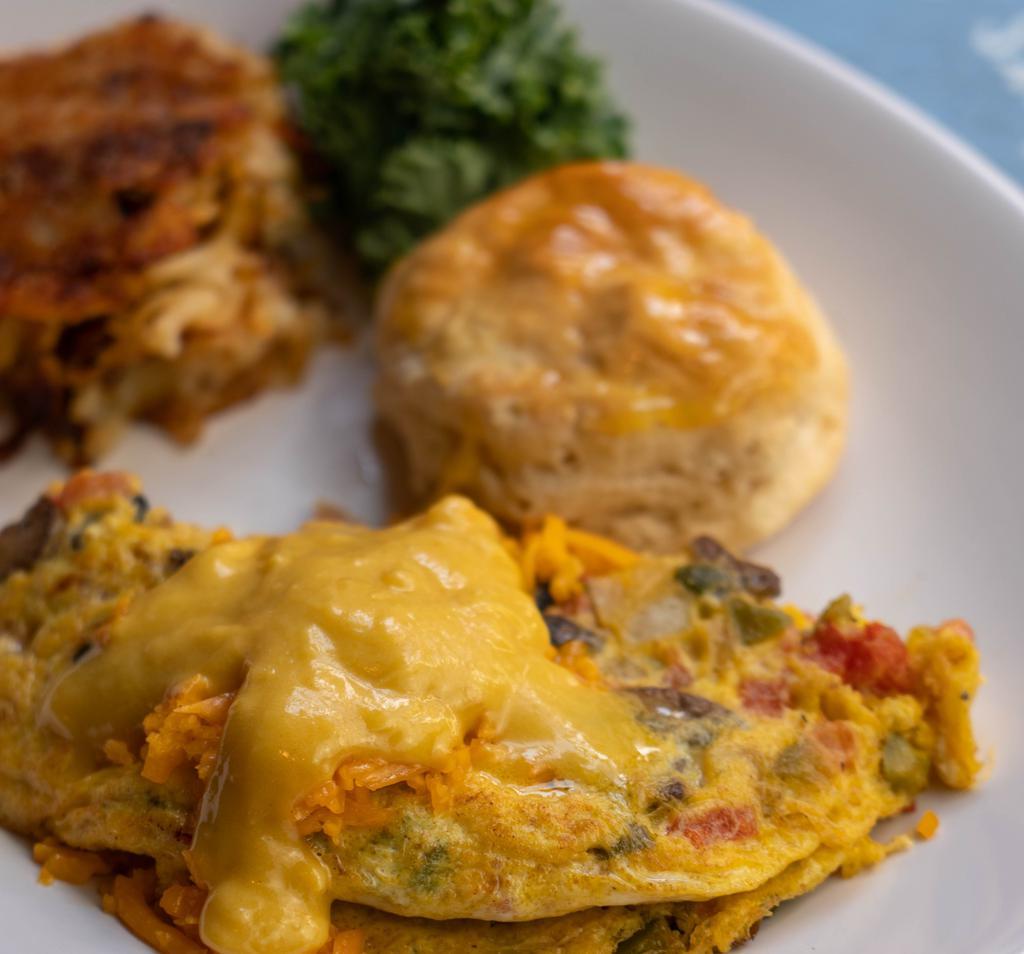 Vegetarian Omelette · Vegetarian. Tomatoes, onions, mushrooms, green peppers, Cheddar cheese, topped with Hollandaise sauce. Served with hash browns and a biscuit.