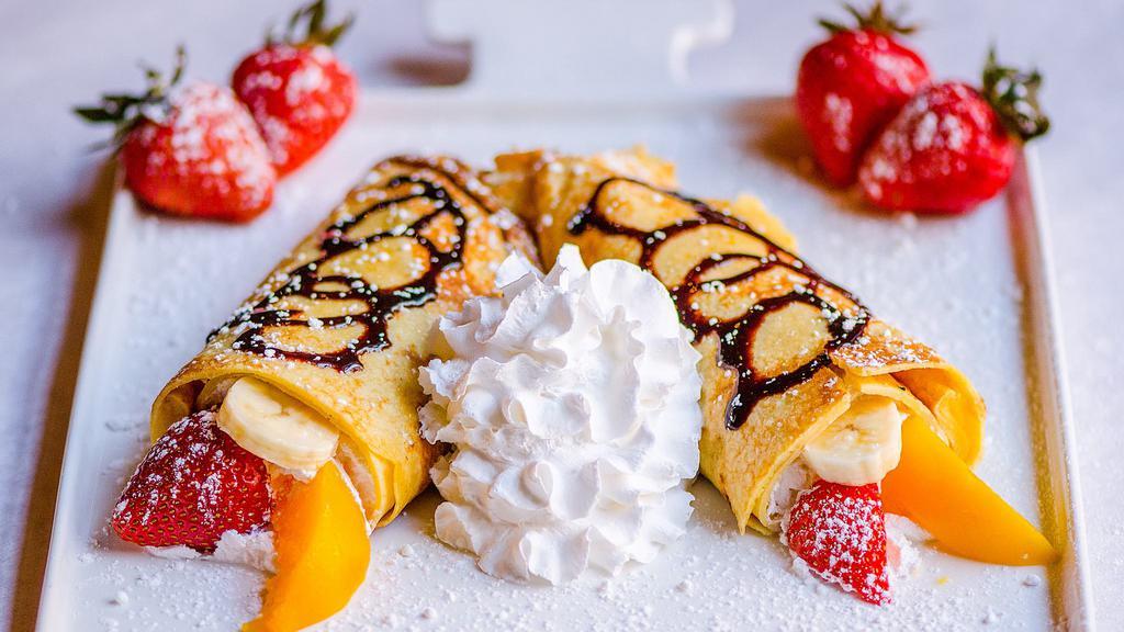 Dessert Crepe · Slices of strawberry, peaches and bananas topped with whipped cream and honey.