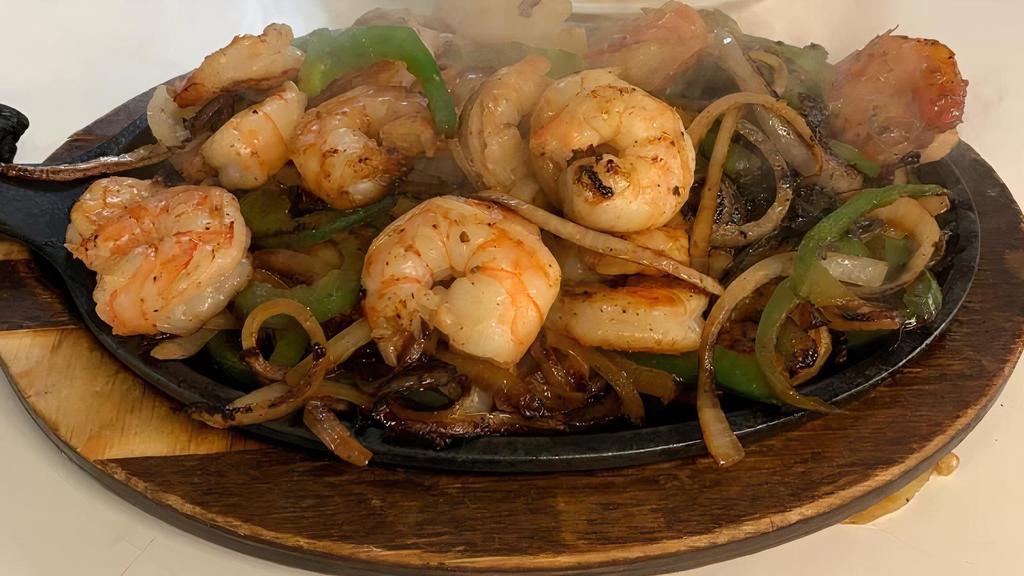 Fajitas De Camarón · Shrimp sizzling fajitas cooked with cactus,
bell peppers and onions garnished with cilantro with black refried beans, rice, lettuce, tomatoes, avocado, sour cream & limes on the side. Served with your choice of flour or corn tortillas.