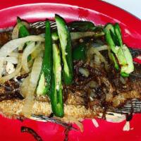 Mojarra Frita · A fried Queen tilapia topped with grilled onions and jalapeños served with black refried bea...