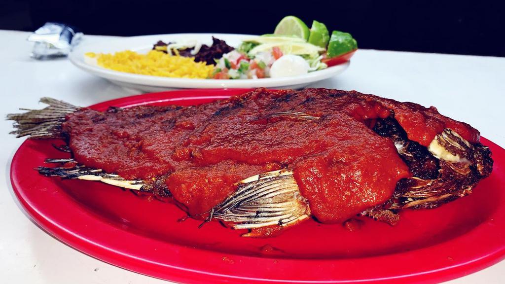 Mojarra Al Chipotle · Whole fried tilapia topped with a special spicy chipotle sauce. Served with salad, rice, beans and tortillas.