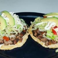 Sopes · Two round thick flattened pieces of grilled corn dough topped with your choice of meat, blac...