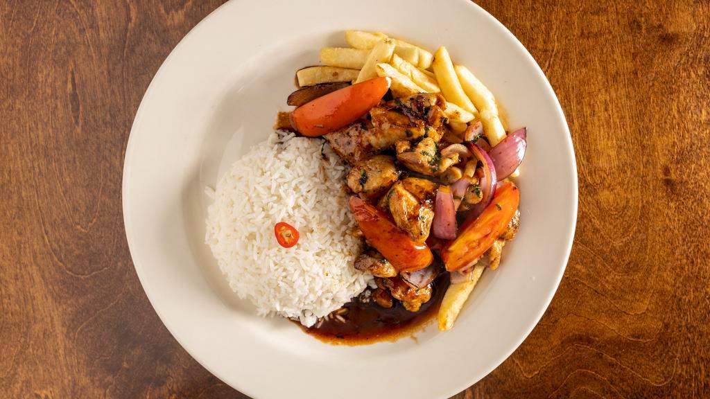 Pollo Saltado · Delicious pieces of chicken sautéed with onion bright tomatoes in a fiery wok served with rice and fries.