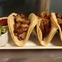 Tacos De Carnitas · Slow cooked pork in three soft corn tortillas. Served with cilantro and onion, hot salsa, an...
