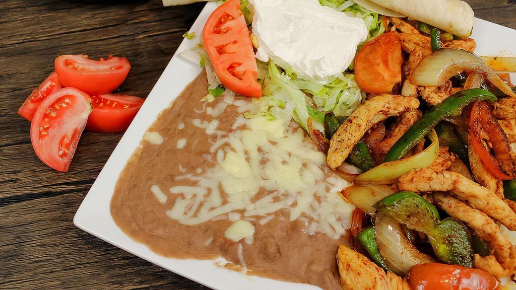 Fajita Express · Steak or chicken grilled with peppers, onions, and tomatoes. Served with beans, lettuce, sour cream, tomato, cheese, and tortillas.  Add guacamole for .95 more.