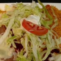 Mexican Burrito · Burrito filled with beef tips topped with red sauce, cheese dip, and crema salad. Served wit...