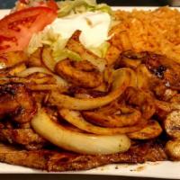 Steak Tolteca · Ribeye steak topped with grilled onions and mushrooms. Served with rice, crema salad, and to...