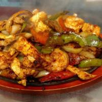 Texas Fajitas · Tender beef, chicken and shrimp grilled with onions, tomatoes and bell peppers. Served with ...