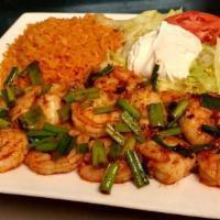 Camarones Al Mojo De Ajo · Shrimp and onions sauteed in garlic and butter. Served with rice, crema salad, and tortillas.