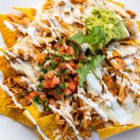 Nachos · A bed of corn tortilla chips, cheese dip, sour cream, guacamole, and pico de gallo on top. M...