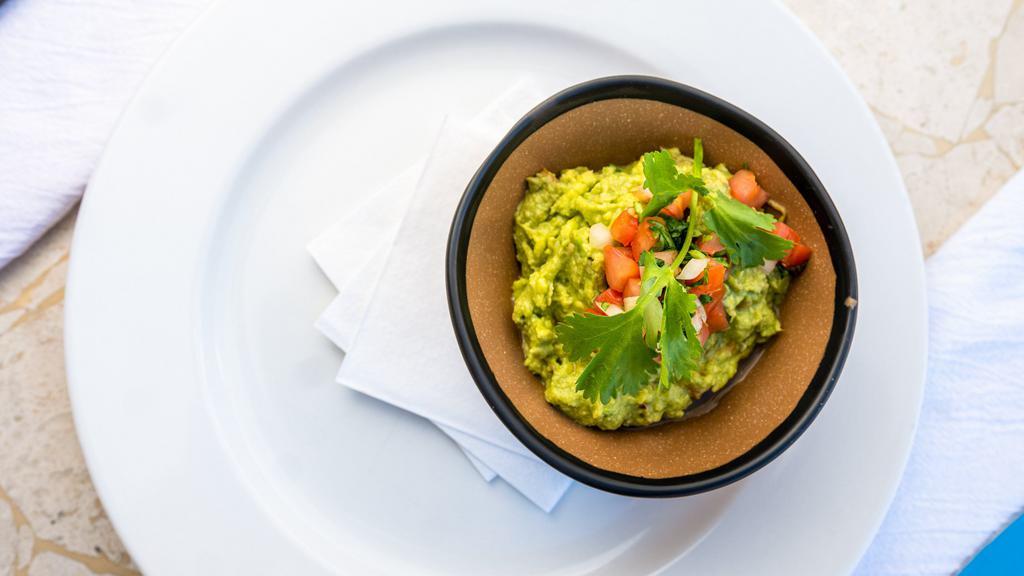 Mashed Avocados · Our traditional guacamole recipe from Veracruz, Mexico. Fresh avocados mashed with fresh cilantro and serrano sauce. Served with corn tortilla chips.
