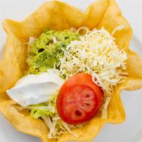 Tacos Salad · Taco shell with lettuce, tomato, sour cream, and your choice of ground beef or shredded chic...