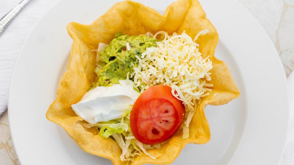 Tacos Salad · Taco shell with lettuce, tomato, sour cream, and your choice of ground beef or shredded chicken.