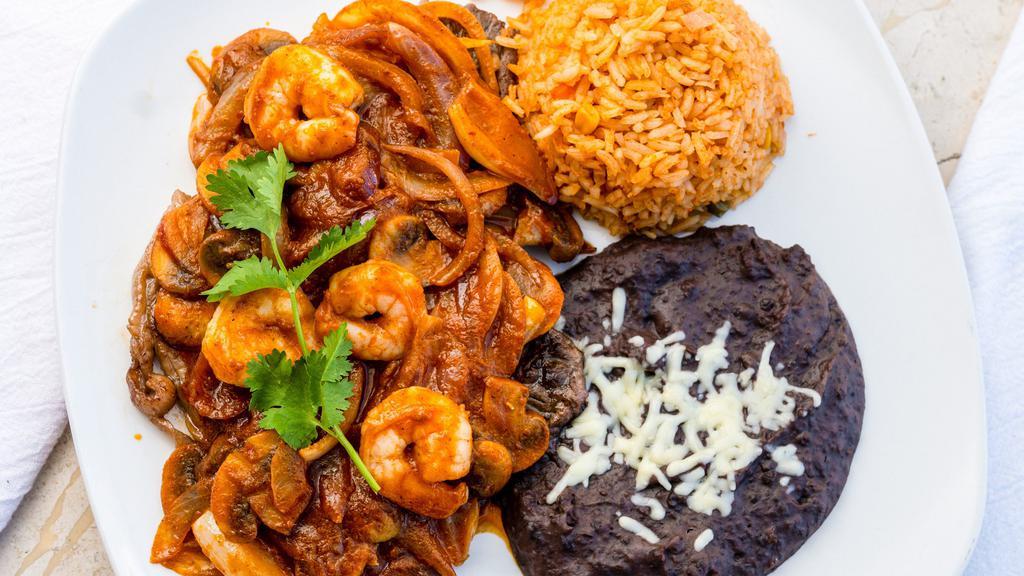 Steak And Shrimp · 6 oz. Rib eye steak cooked with special garlic sauce, sautéed shrimp cooked with mushrooms, red onions, Oaxaca cheese, and adobo red sauce. Served with rice and refried black beans.