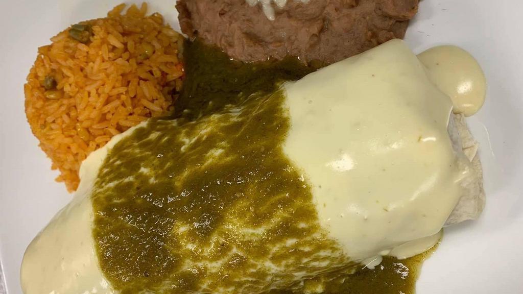 Burrito Al Carbón · Grilled steak cooked with bell peppers and red onions, topped with cheese dip and green poblano sauce. Served with rice and pinto beans.