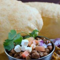 Chole Bhature · Chickpea curry served with two large fluffy bhaturas (leavened bread), onions, and pickle. O...