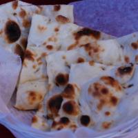 Tandoori Naan · Classic leavened, oven-baked flatbread topped with butter.
