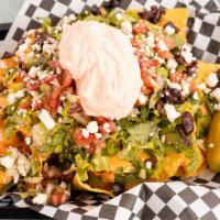 Greek Nachos · Lettuce, Greek salsa, banana peppers, bell peppers, cheese sauce, topped with feta and drizz...