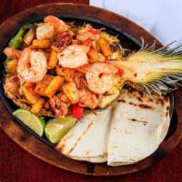 Pina Fajitas (Pineapple Fajita) · Fresh pineapple stuffed with grilled steak or chicken, onions, tomatoes, and bell peppers. S...
