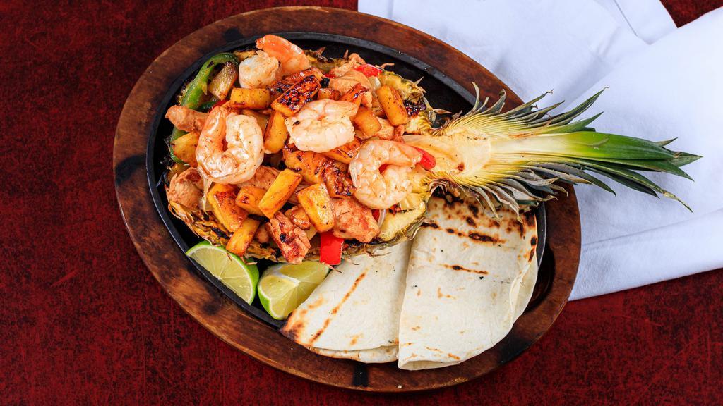 Pina Fajitas (Pineapple Fajita) · Fresh pineapple stuffed with grilled steak or chicken, onions, tomatoes, and bell peppers. Served with rice and beans, lettuce, guacamole, sour cream, pico de gallo, and tortillas.