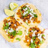Tacos · Corn tortilla. Garnished with chopped onions and cilantro.