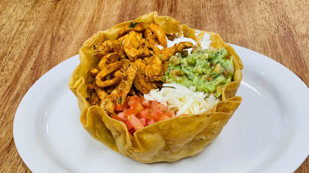 Taco Salad · Crispy tortilla bowl. Topped with lettuce, tomato, shredded cheese, guacamole, sour cream, rice and beans.