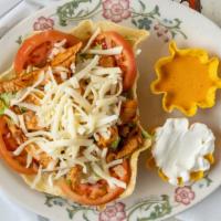 Taco Salad · Crispy flour tortilla shell tilled with refried beans, nacho cheese, and beef and pico de ga...
