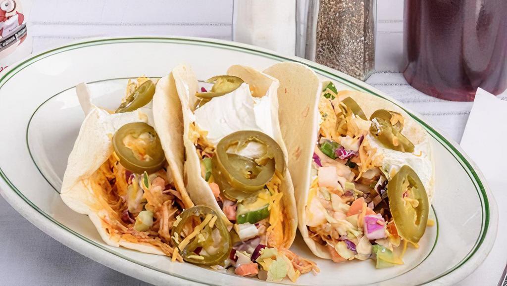 Red Hot Tacos · Soft taco shells stuffed with our red hot buffalo chicken and creamy cole slaw topped with shredded cheese, jalapenos, sour cream, and green onions.